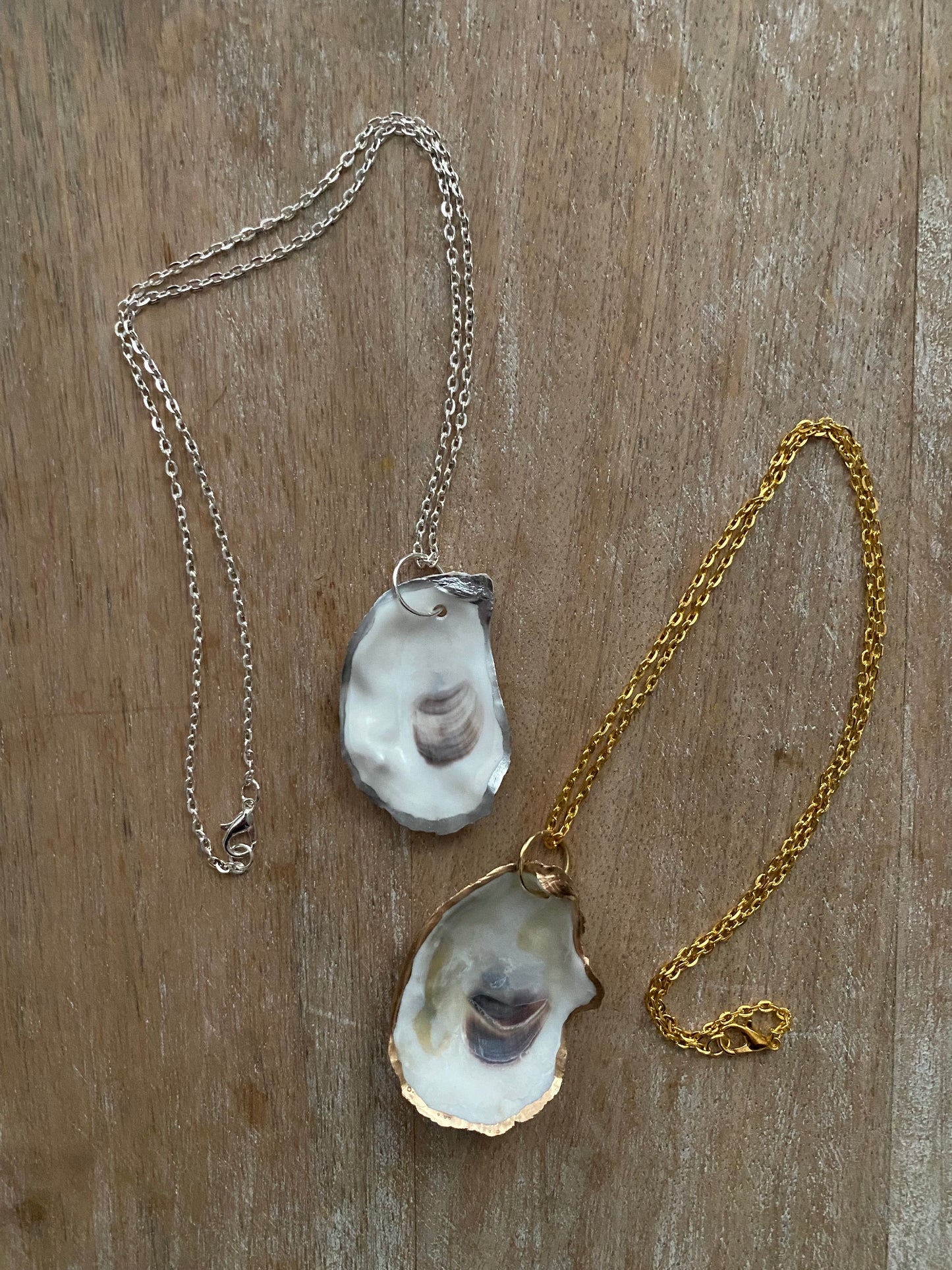 Single oyster shell pendant on gold or silver chain.