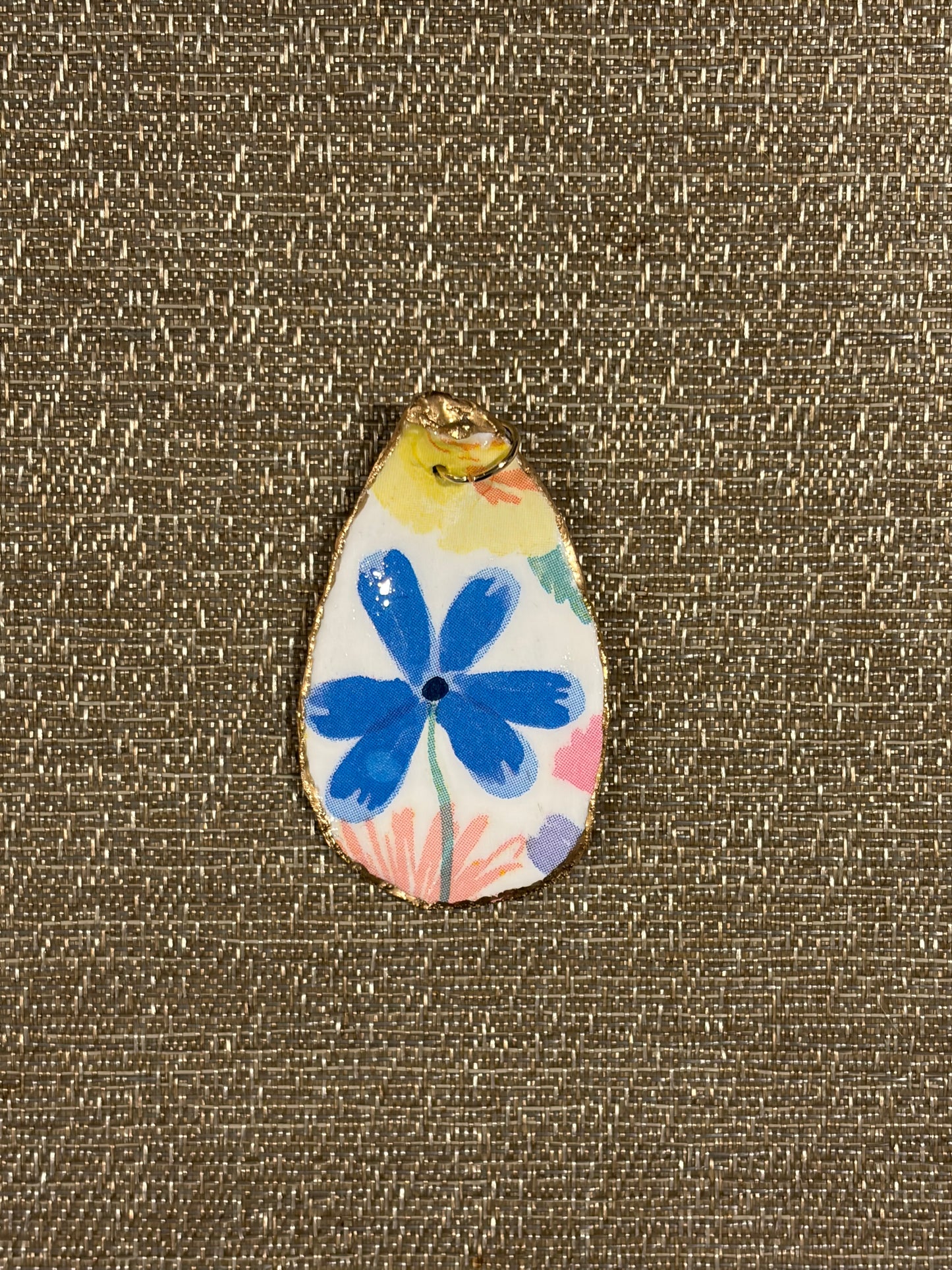 Oyster shell pendant with a blue flower design