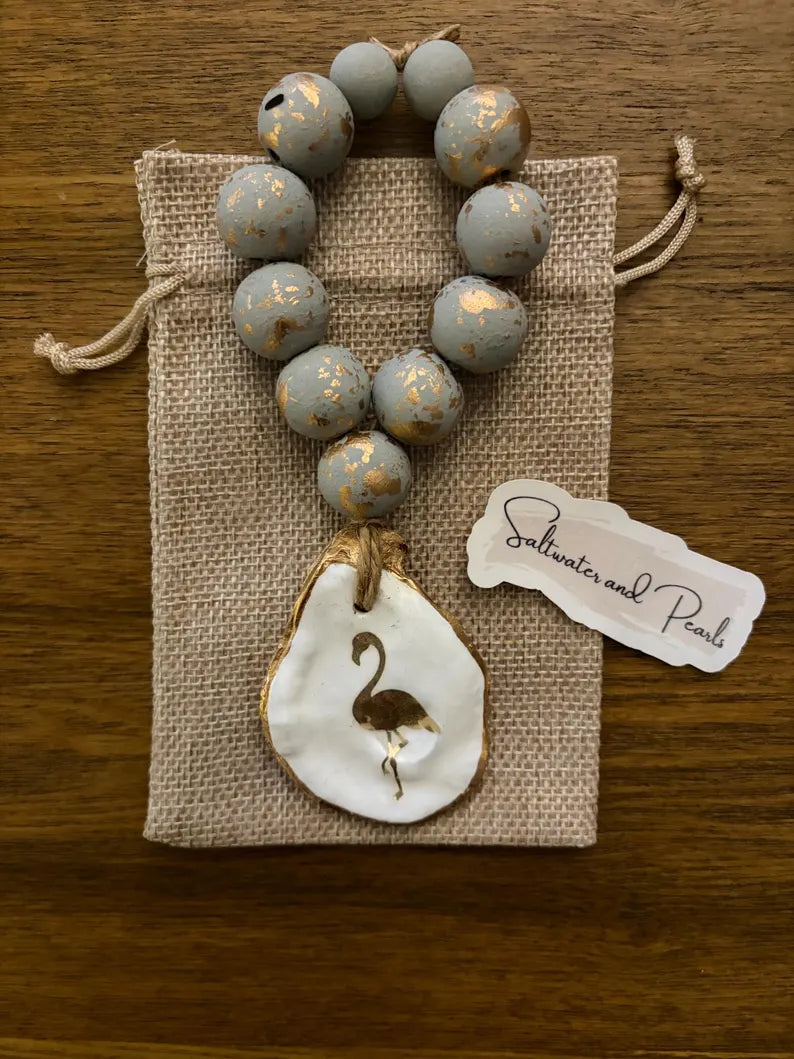 Oyster shell napkin ring/wine bottle charm with image of flamingo on shell attached to hand painted grey beads