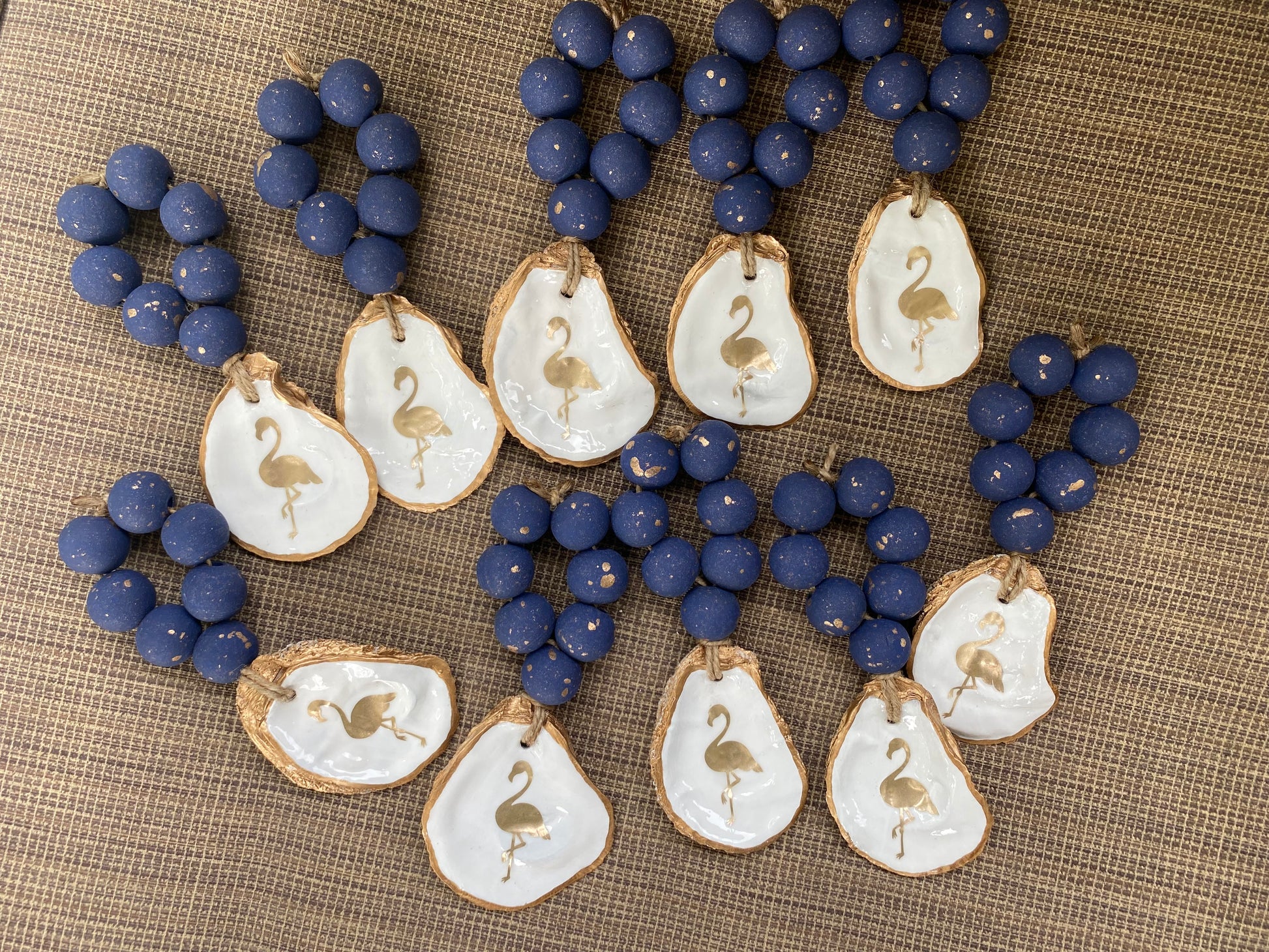 Oyster shell napkin ring/wine bottle charm with image of flamingo on shell attached to hand painted navy blue beads